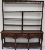 An 18th century South Wales oak dresser, the open rack with a moulded cornice and three shelves,