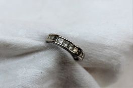 A diamond half eternity ring set with nine princess cut diamonds totalling 1ct to a platinum