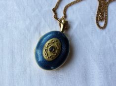 An 18ct gold and blue guilloche enamel and cabochon locket of oval form on a 9ct yellow gold