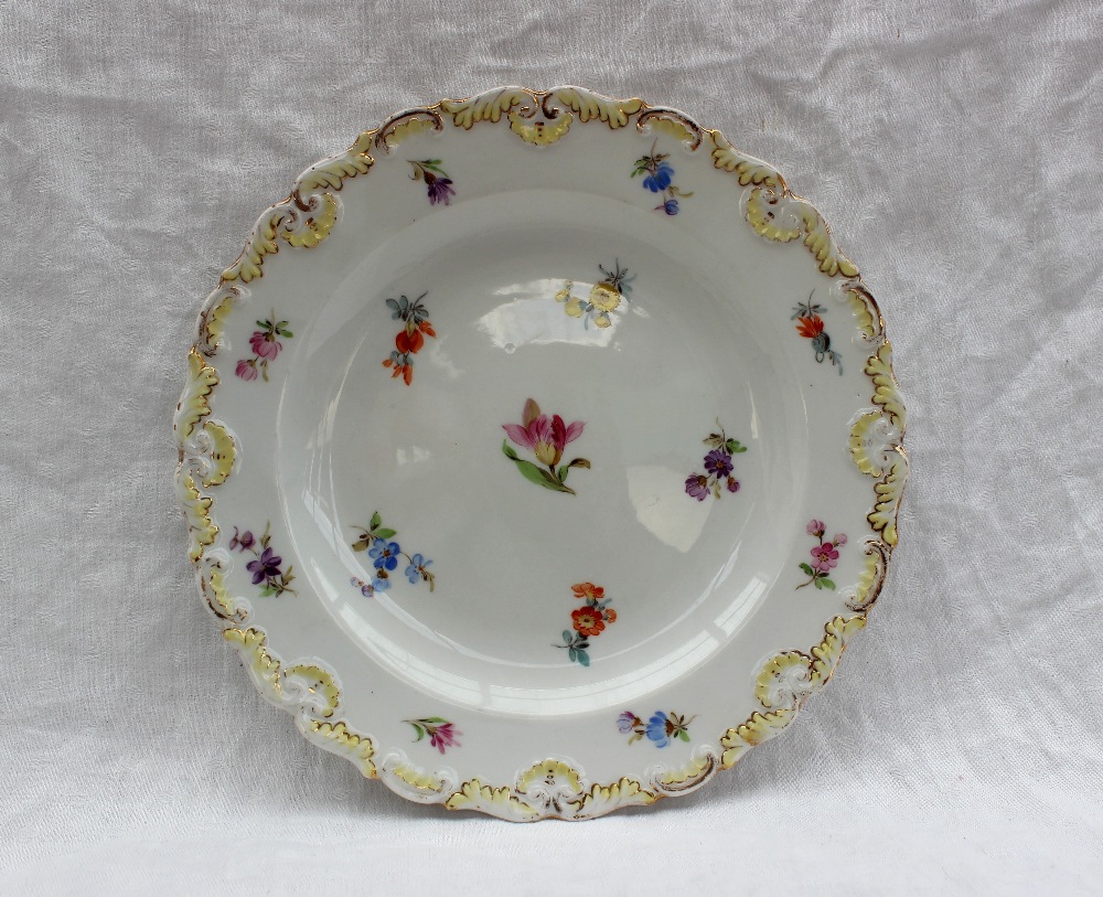 A Meissen porcelain side plate, with a shaped raised edge painted with small flowerheads,