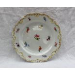 A Meissen porcelain side plate, with a shaped raised edge painted with small flowerheads,