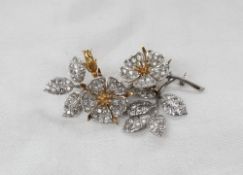 An 18ct yellow and white gold brooch in the form of flower heads,