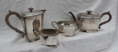 A George V silver four piece tea service, of tapering rectangular form, comprising a hot water jug,