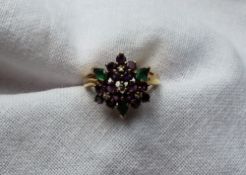 A diamond, amethyst and emerald cluster ring set with four brilliant cut diamonds,