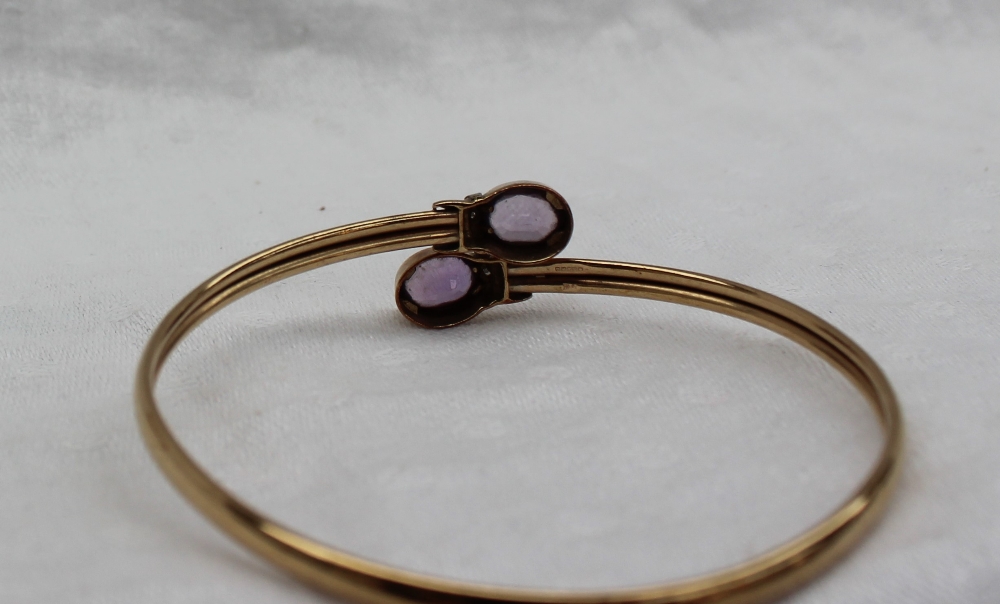 A 9ct yellow gold bangle, set with two oval faceted amethysts, - Image 3 of 3