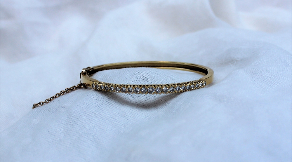 An 18ct yellow gold hinged bangle, set with twenty one round brilliant cut diamonds, - Image 2 of 4