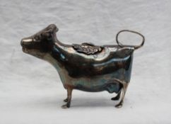 An Elizabeth II silver cow creamer, of naturalistic form, with a fly topped hinged pad,