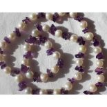 A pearl and amethyst necklace set with thirty five pearls and amethyst chips to a lobster claw