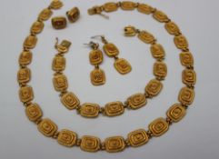 A matching yellow metal bracelet, necklace and earrings,