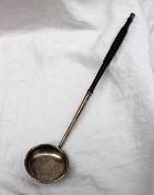 A white metal toddy ladle with makers mark for William Ferguson ladle on a turned and tapering