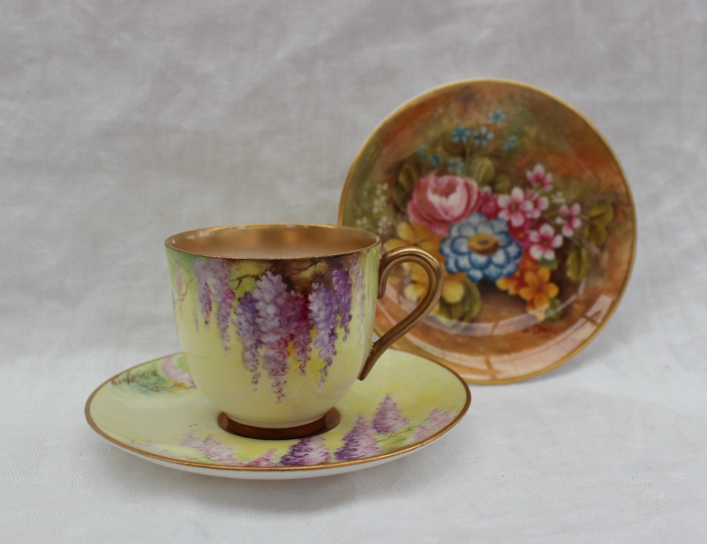 A Royal Worcester porcelain cabinet cup and saucer, painted with wisteria to a yellow ground,