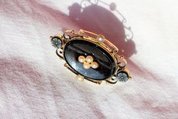 A Victorian onyx and seed pearl mourning brooch,