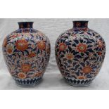 A pair of Japanese Imari vases, decorated with flowerheads and leaves,