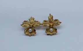 A pair of yellow metal and pearl earrings, of leaf form,