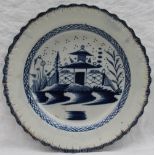 A 19th century pearlware plate with a feather edge, painted to the centre with pagodas and a river,