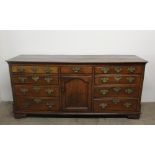 An 18th century North Wales oak dresser base, the rectangular planked top with cut corners,