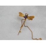 A yellow metal brooch, in the form of a dragonfly with an amethyst set body,