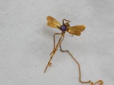 A yellow metal brooch, in the form of a dragonfly with an amethyst set body,