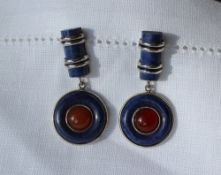 A pair of lapis lazuli and white metal drop earrings with a domed panel and circular panel marked