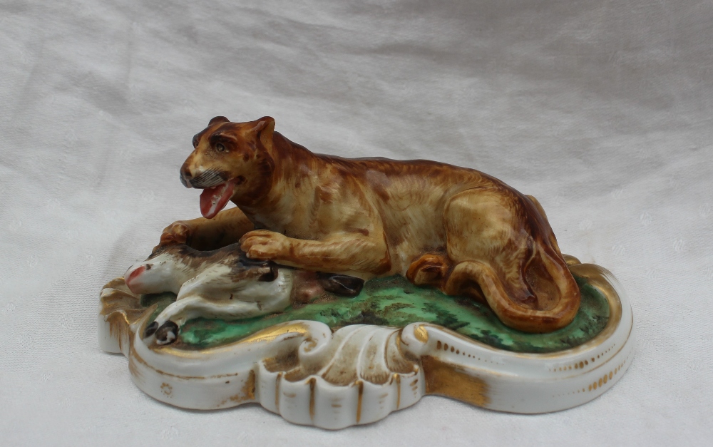 A 19th century porcelain figure group of a lion subduing a deer, on a scrolling oval base, 14.