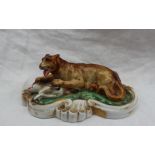 A 19th century porcelain figure group of a lion subduing a deer, on a scrolling oval base, 14.