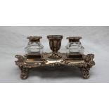 A late Victorian silver desk standish, with a central urn and two glass and silver topped inkwells,