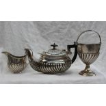 A Victorian silver swing handled sugar basket of urn form on a spreading foot with gadrooned