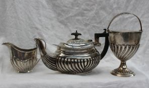 A Victorian silver swing handled sugar basket of urn form on a spreading foot with gadrooned