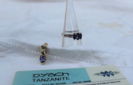 A tanzanite and diamond ring set with three marquise cut tanzanites and twelve round brilliant cut