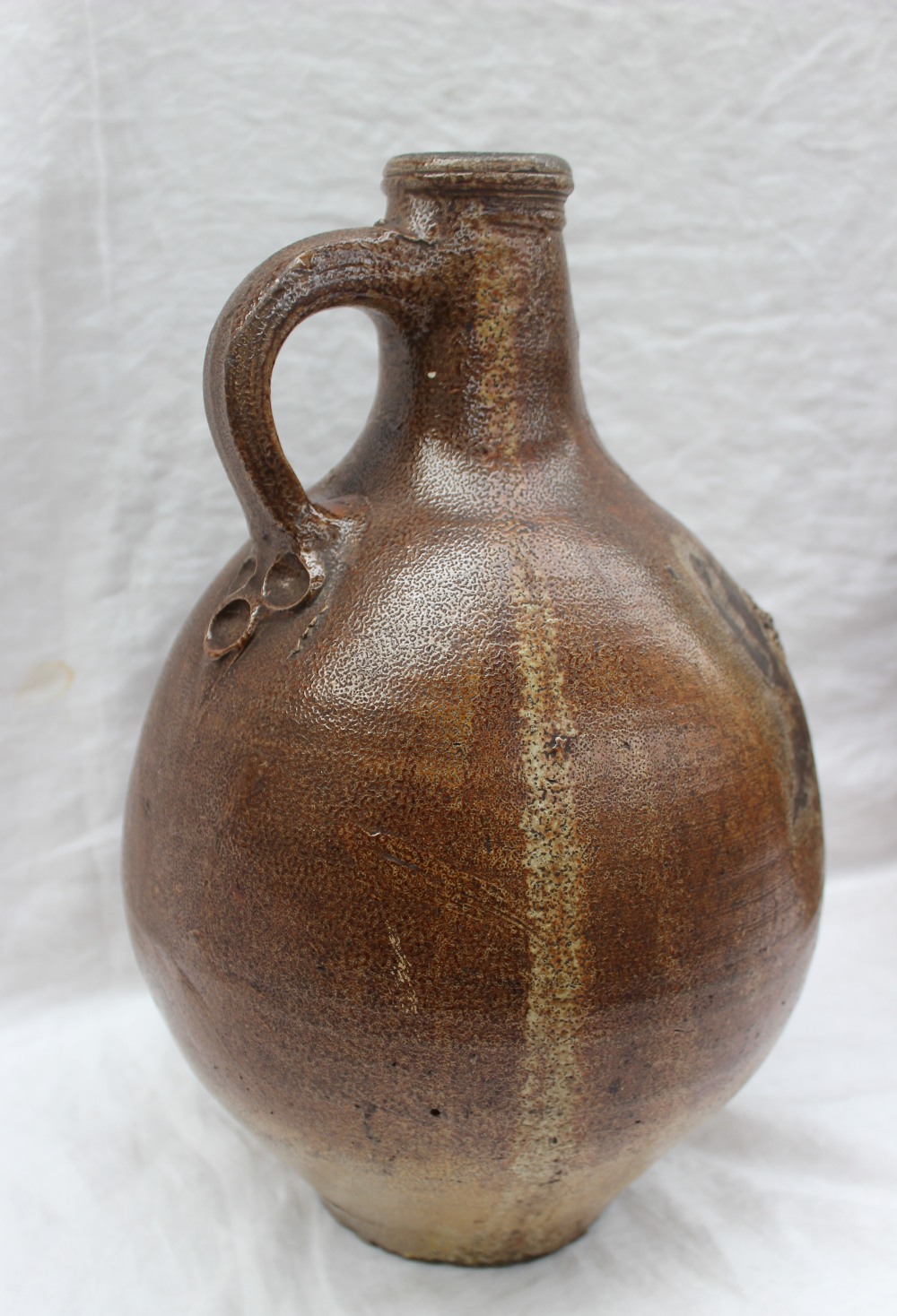 A large 18th century salt glazed Bellarmine mask jug, with a ring handle and finger marks, - Image 7 of 10