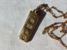 A 9ct yellow gold ingot, London, 1977, approximately 32 grams on a 15ct yellow gold oval link chain,