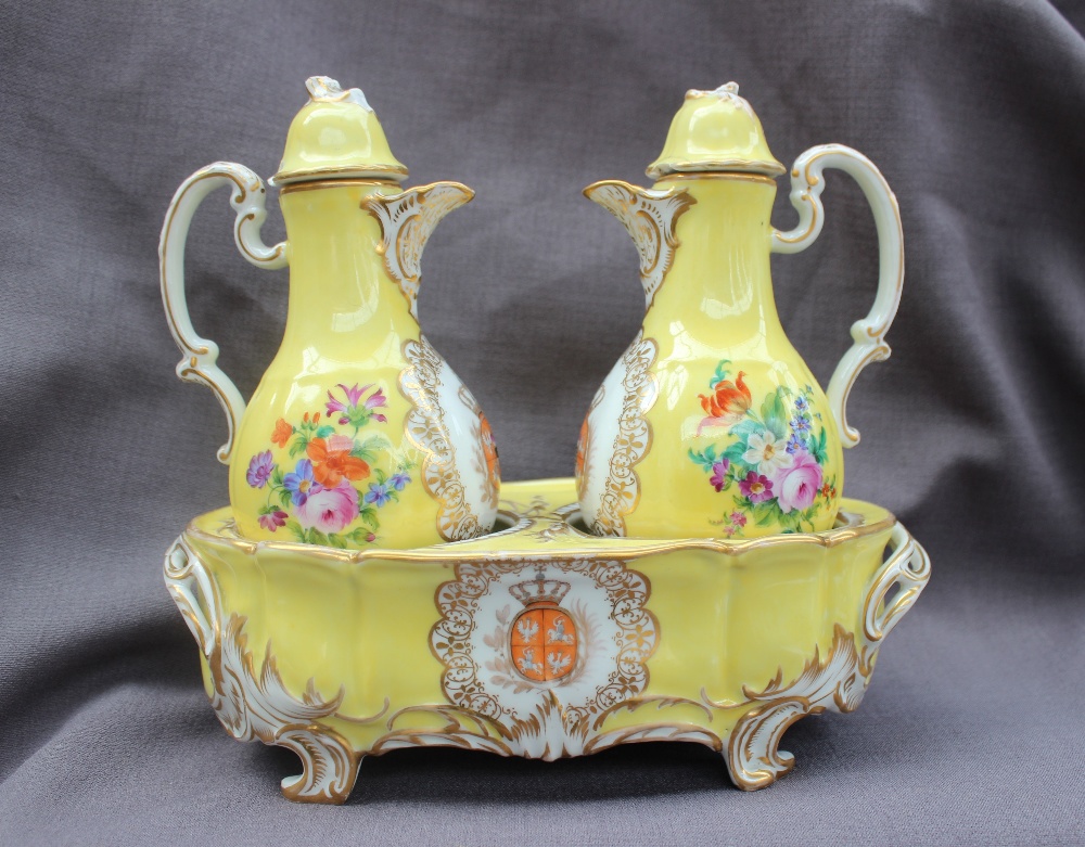 A 19th century continental porcelain oil and vinegar set in an oval stand,