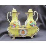 A 19th century continental porcelain oil and vinegar set in an oval stand,