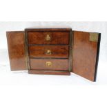 A 19th century walnut table top cabinet with a pair of cupboard doors enclosing three graduated