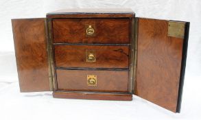 A 19th century walnut table top cabinet with a pair of cupboard doors enclosing three graduated