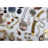 A silver locket together with a large collection of costume jewellery including rings, brooches,