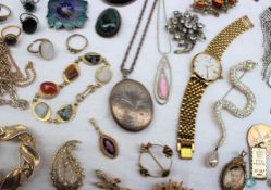 A silver locket together with a large collection of costume jewellery including rings, brooches,