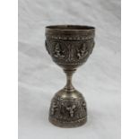 An Indian white metal double sided spirit measure, embossed with figures in roundels, 10cm high,