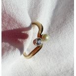 A diamond and pearl crossover ring, set with a round brilliant diamond approximately 0.