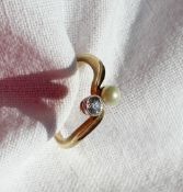 A diamond and pearl crossover ring, set with a round brilliant diamond approximately 0.