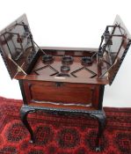 A 20th century mahogany cocktail cabinet, the rectangular panelled top with square inset handles,