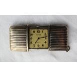 A continental white metal Movado chronometre Ermeto purse watch, with a sliding ribbed body,