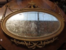 A gilt gesso wall mirror with a central vase and swag decoration