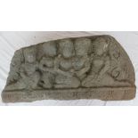 A carved reconstituted stone panel depicting Indian figures in a line on a lotus leaf carved base,