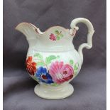 A 19th century pottery jug, painted with flowerheads and leaves on a spreading foot,