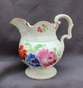 A 19th century pottery jug, painted with flowerheads and leaves on a spreading foot,