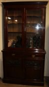 An Edwardian walnut bookcase the moulded dentil cornice above a pair of glazed doors,