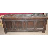 A large 18th century oak coffer with a four panelled top and front on stiles