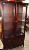 A reproduction mahogany display cabinet with a pair of glazed doors, with glazed sides,