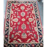 A small Persian red ground rug with floral swags
